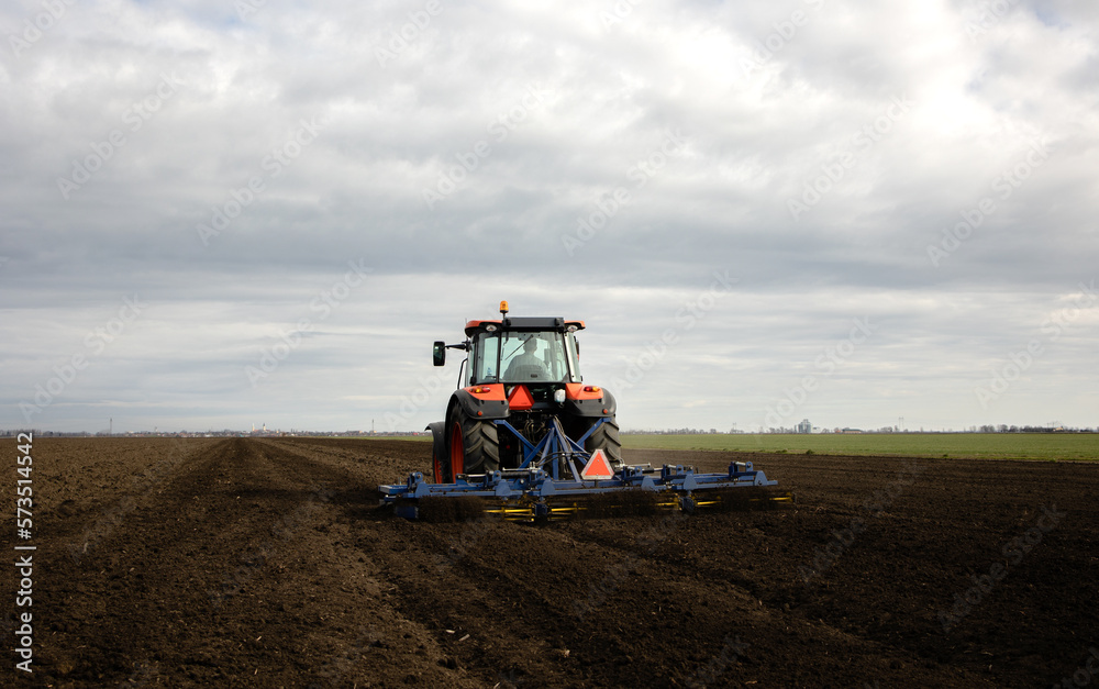 Tractor is preparing the land at dusk Tractor is preparing the land at dusk