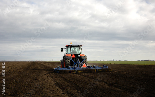 Fototapeta Naklejka Na Ścianę i Meble -  Tractor is preparing the land at dusk