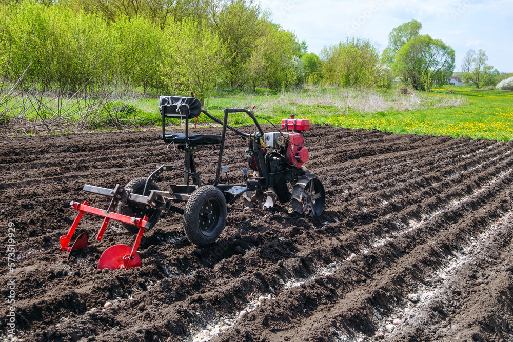 Small farm tractor equipped with mounted disc hiller. Gasoline