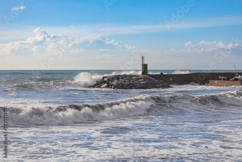 Rough sea on the pier of Recco with the lighthouse, Genoa province, Italy.