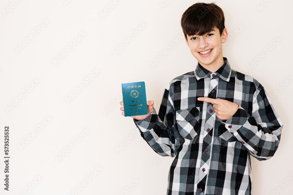 Young teenager boy holding Taiwan passport looking positive and happy standing and smiling with a confident smile against white background. Young teenager boy holding Taiwan passport looking positive and happy standing and smiling with a confident smile against white background.