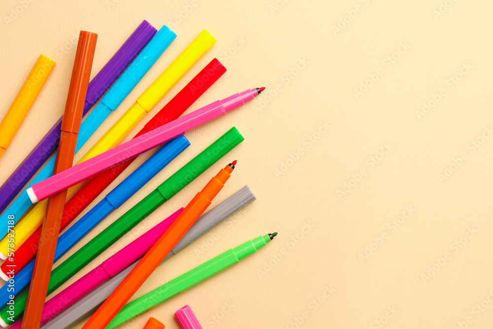 Fototapeta premium Many bright markers on beige background, flat lay. Space for text