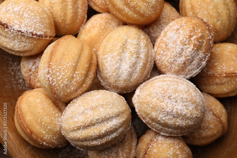 Delicious nut shaped cookies with boiled condensed milk and powdered sugar on wooden table, top view Delicious nut shaped cookies with boiled condensed milk and powdered sugar on wooden table, top view