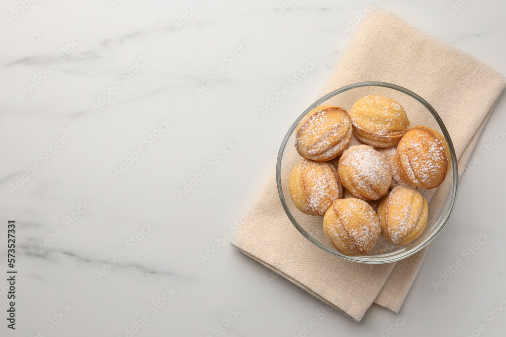 Homemade walnut shaped cookies with condensed milk on white marble table, top view. Space for text Homemade walnut shaped cookies with condensed milk on white marble table, top view. Space for text