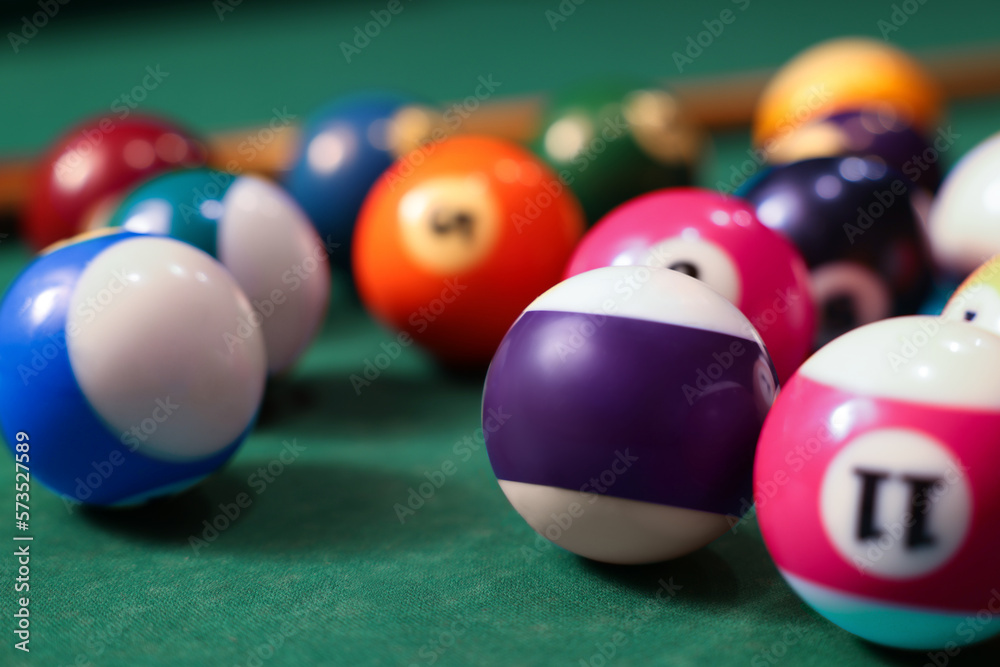 Many colorful billiard balls on green table, closeup
