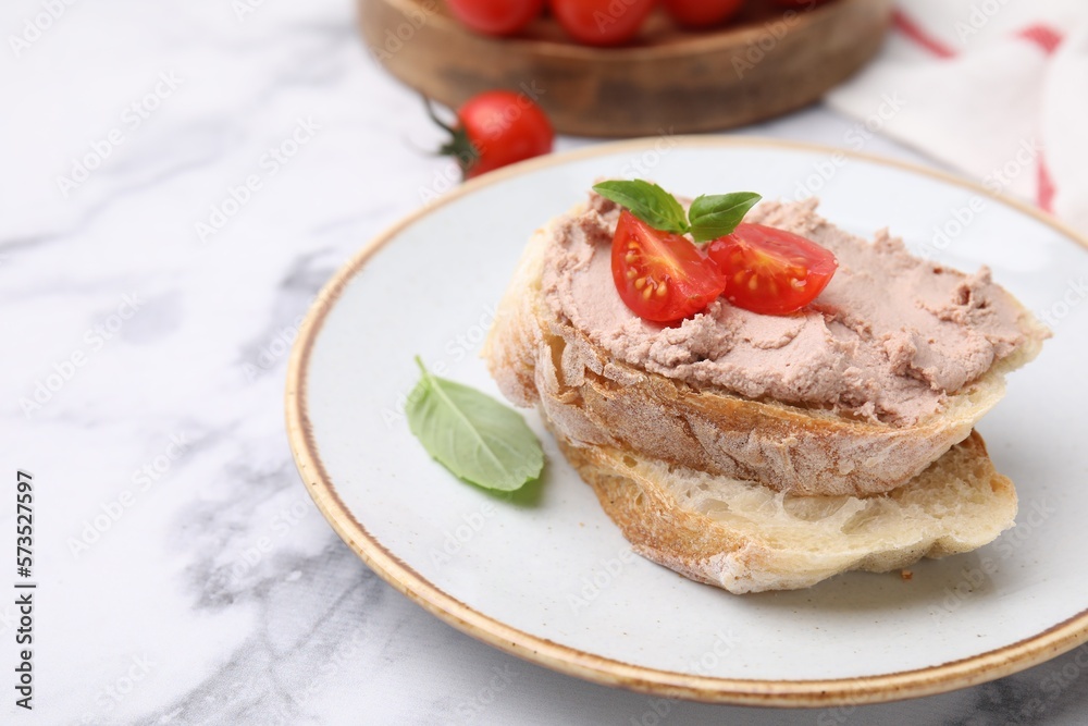 Delicious liverwurst sandwich with tomatoes and basil on white marble table