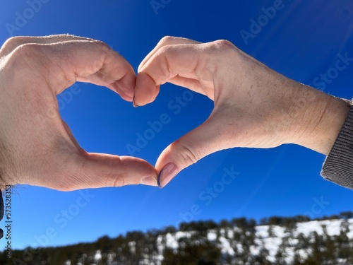heart shaped hands against blue sky male and female