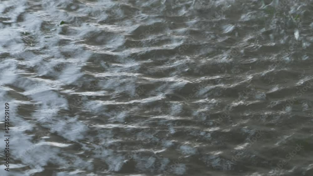 Slow motion of water droplets bursting over a puddle on a rainy day Slow motion of water droplets bursting over a puddle on a rainy day
