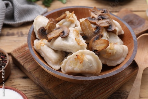 Delicious dumplings  varenyky  with potatoes  onion and mushrooms served on wooden table  closeup