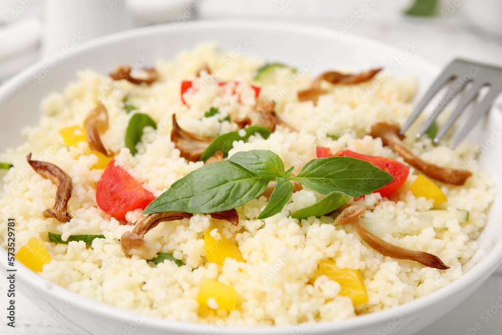 Bowl of delicious couscous with vegetables and basil, closeup Bowl of delicious couscous with vegetables and basil, closeup