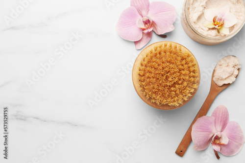 Flat lay composition with spa products and flowers on white marble table. Space for text