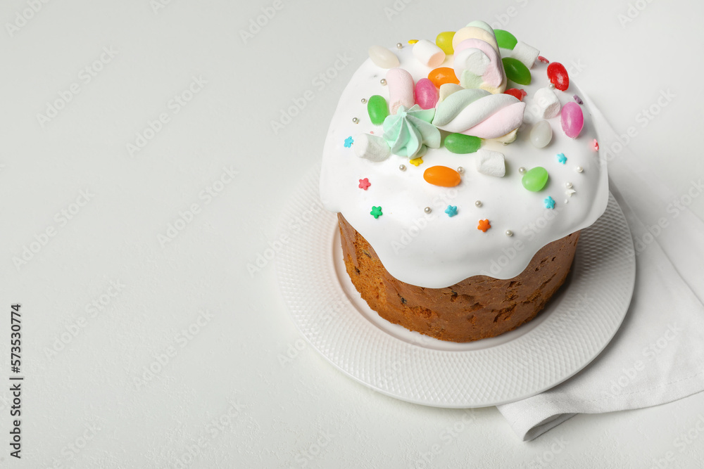 Traditional Easter cake decorated with sprinkles, jelly beans and marshmallows on white table, space for text