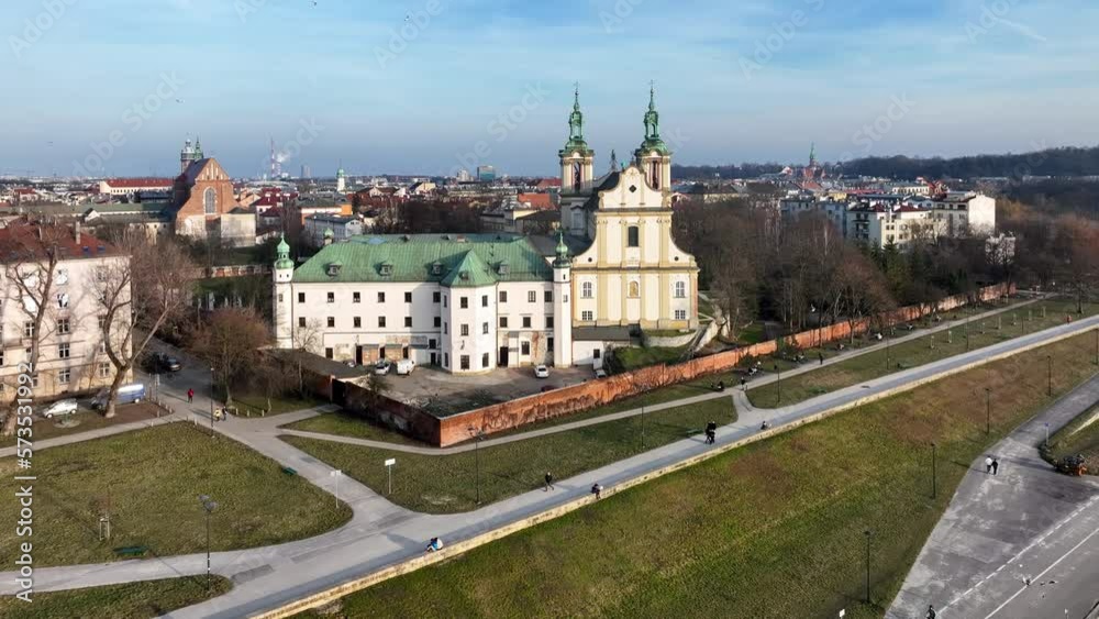 Skalka, church na Skalce in Krakow, Poland. St. Stanislaus church and Paulinite monastery. Burial place of distinguished Poles. Aerial view. Winter, sunset light. Promenade with walking people Skalka, church na Skalce in Krakow, Poland. St. Stanislaus church and Paulinite monastery. Burial place of distinguished Poles. Aerial view. Winter, sunset light. Promenade with walking people