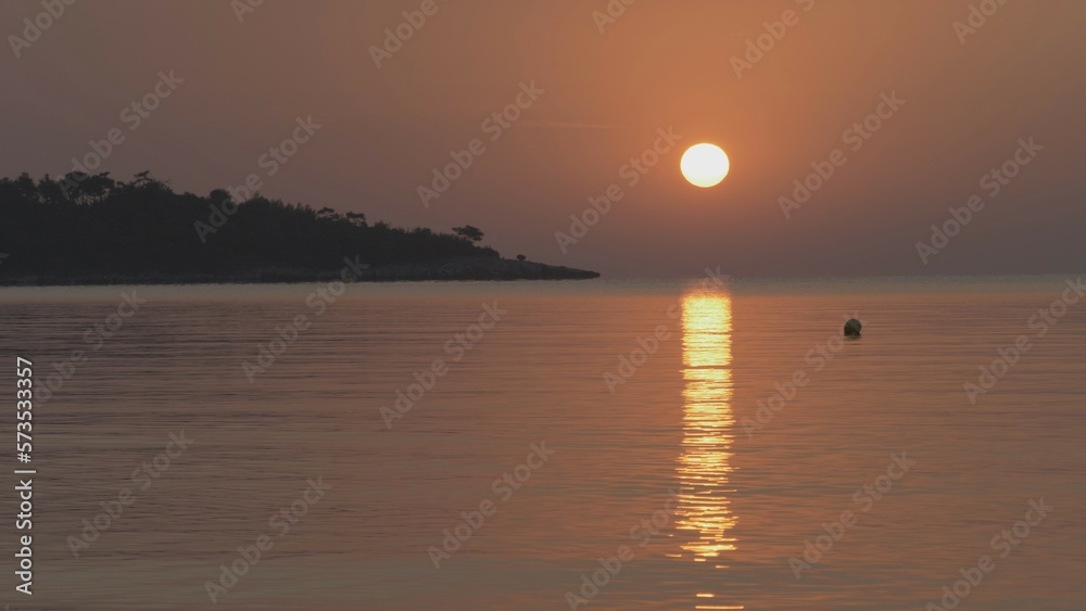 Sunrise reflected in the sea near the coast of the island Sunrise reflected in the sea near the coast of the island