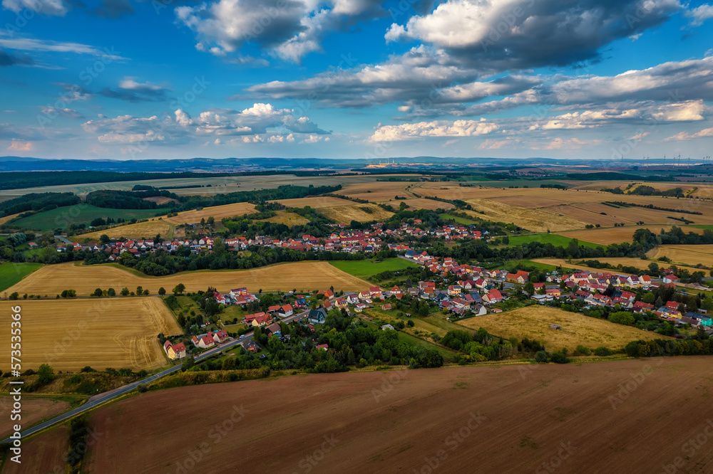 Aer ial view of a German village surrounded by meadows, farmland and forest in Germany.