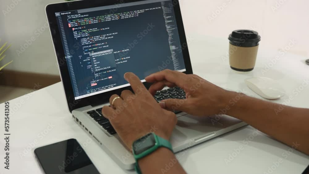 Web application development. programmer man writing program code sitting at workplace in office, software developer hands coding HTML programming with laptop computer, IT start up concept, back view