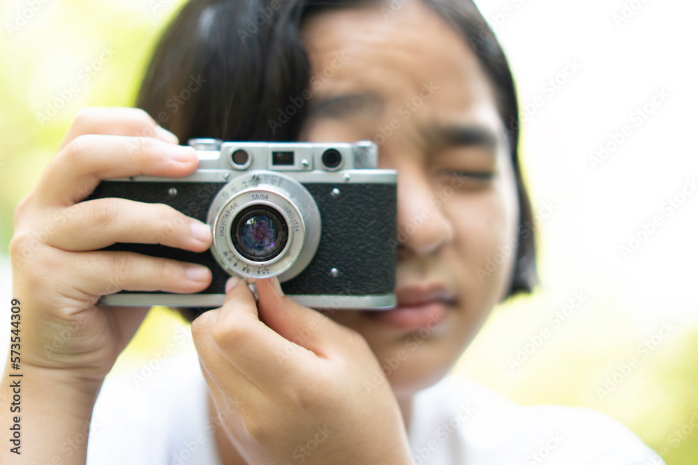 film camera in the hands of a girl taking a picture. Green trees boudoir backdrop.woman taking photos with a camera, selective focus, soft focus. film camera in the hands of a girl taking a picture. Green trees boudoir backdrop.woman taking photos with a camera, selective focus, soft focus.