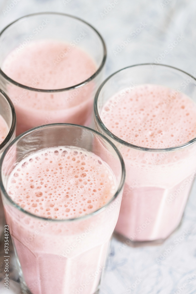 Top view on glasses of strawberry milkshake or smoothie on table. Top view on glasses of strawberry milkshake or smoothie on table.