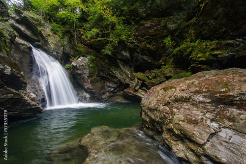 Fototapeta Naklejka Na Ścianę i Meble -  Vermont waterall flows into hidden rocky pool in the forest.