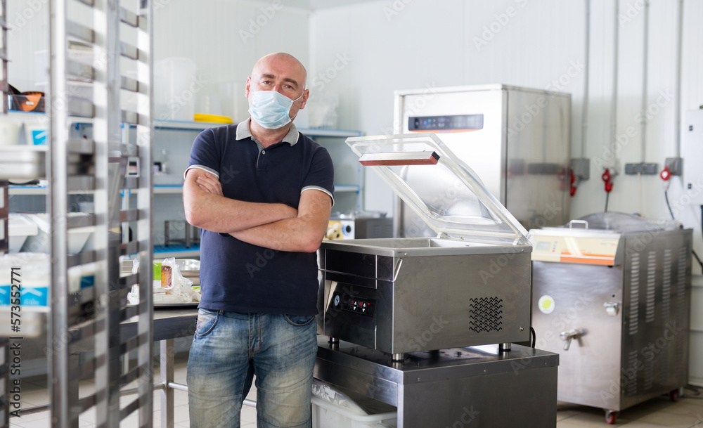 Man in mask on the background of the equipment of the dairy shop Man in mask on the background of the equipment of the dairy shop
