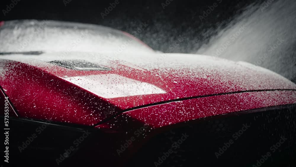 Professional Car Wash Specialist Applying Smart Foam on a Hood of a Red Sportscar with Retro Design at a Dealership Car Detailing Center. Commercial Studio Footage for Automotive Advertising