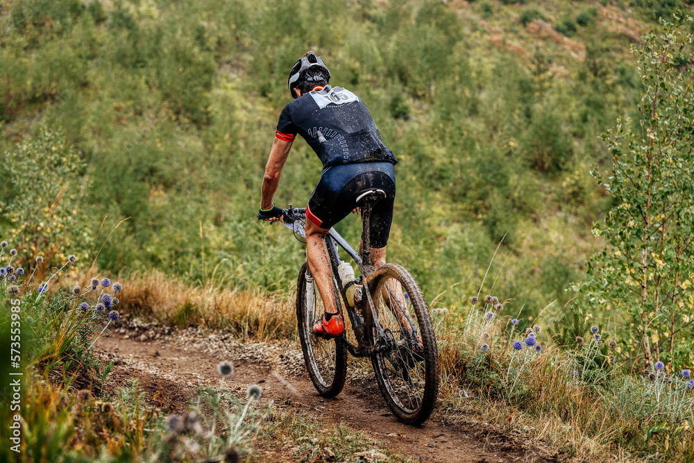 dirty cyclist athlete biking mountain bike on trail. cross country cycling competition dirty cyclist athlete biking mountain bike on trail. cross country cycling competition