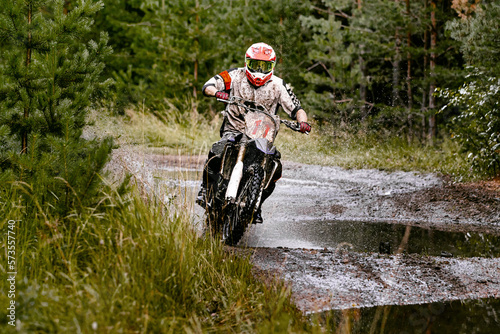 motocross enduro race athlete motorcyclist rides on a forest trail