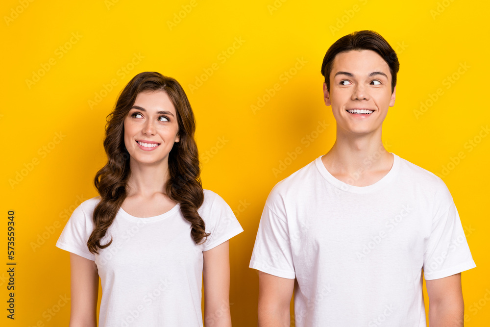 Photo of two young people couple friends girl with guy smiling curious looking mockup wear white t-shirt isolated on yellow color background Photo of two young people couple friends girl with guy smiling curious looking mockup wear white t-shirt isolated on yellow color background