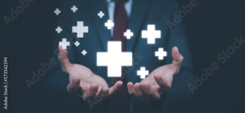 Concept Health care and medical services with technology, Businessman hold in hand offer positive thing such as profit, benefits, development, CSR represented by plus sign, hand shows the plus sign.