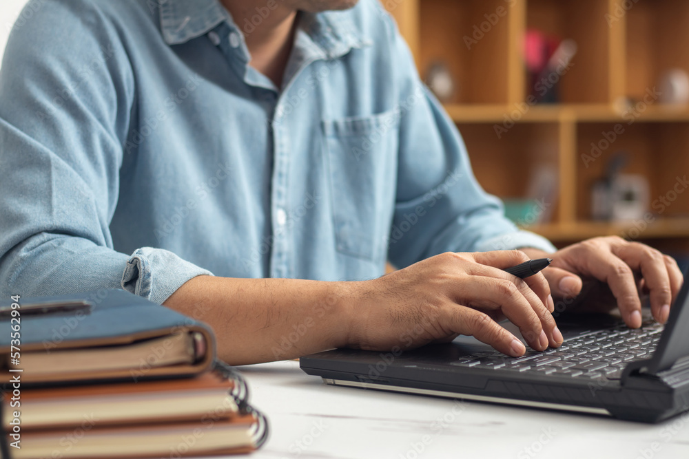 Male hands typing on laptop keyboard and surfing internet on desk, business concept and technology, internet network communication Male hands typing on laptop keyboard and surfing internet on desk, business concept and technology, internet network communication
