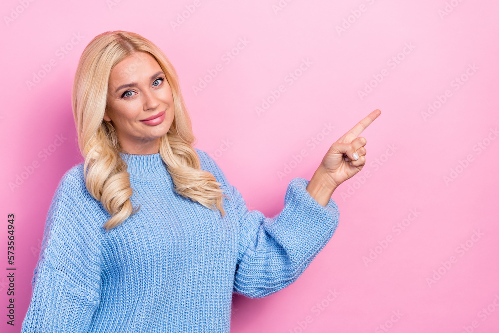 Portrait of adorable good mood girl with wavy hairdo dressed knitwear pullover directing empty space isolated on pink color background Portrait of adorable good mood girl with wavy hairdo dressed knitwear pullover directing empty space isolated on pink color background