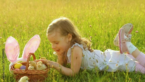 A little girl with a basket of small chicks. Easter holiday