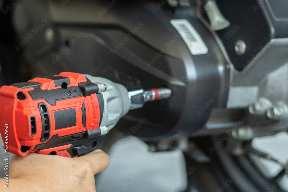 A mechanic is inspecting and repairing a motorcycle in a garage. and fix the engine according to industry standards A mechanic is inspecting and repairing a motorcycle in a garage. and fix the engine according to industry standards