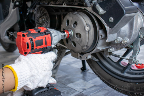 A mechanic is inspecting and repairing a motorcycle in a garage. and fix the engine according to industry standards