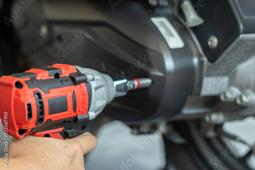 A mechanic is inspecting and repairing a motorcycle in a garage. and fix the engine according to industry standards