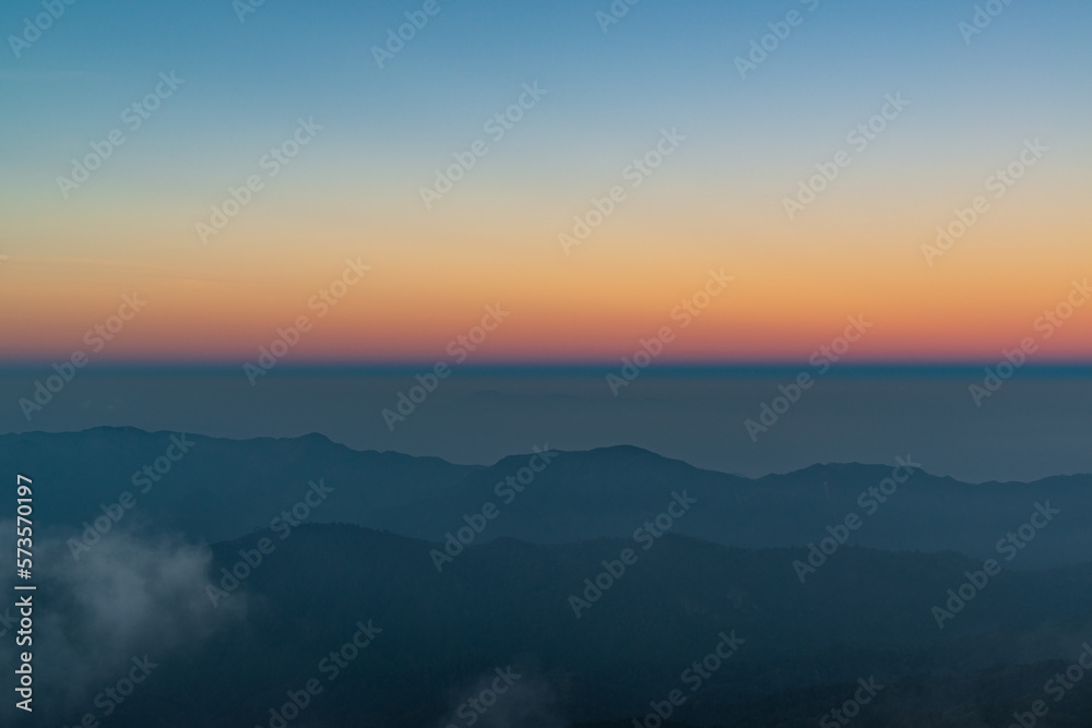 Panoramic twilight view while morning mist covered partly mountain seen from the highest peak of Doi Pha Hom Pok, Fang, Chiang Mai, Thailand.