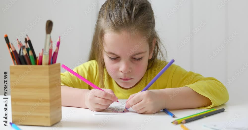 Cute girl drawing with colored pencils at the table Cute girl drawing with colored pencils at the table