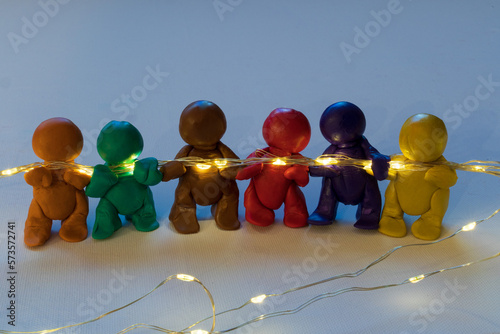 Figuren aus Knete halten eine Lichterkette, symbolische Darstellung für Zusammenhalt.  photo