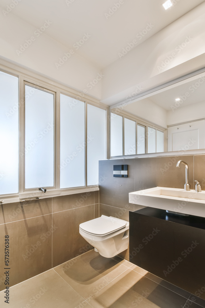 Contemporary bathroom with white sink toilet bowl and tiled walls Contemporary bathroom with white sink toilet bowl and tiled walls
