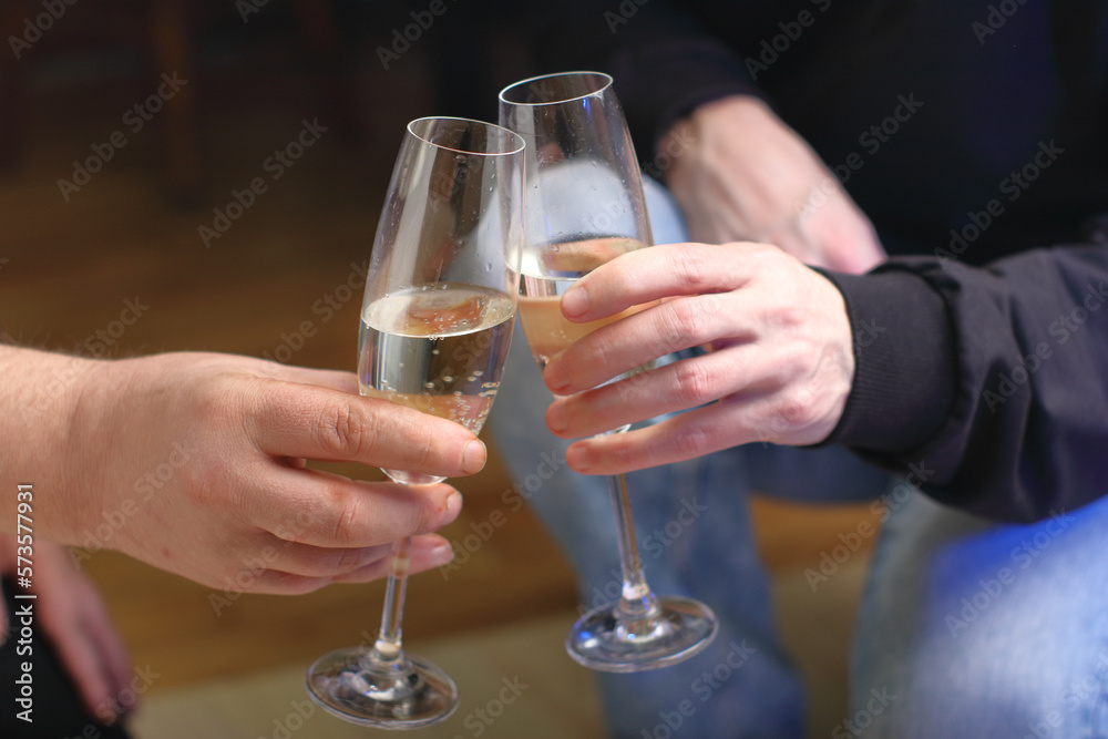 two people clinking glasses with champagne