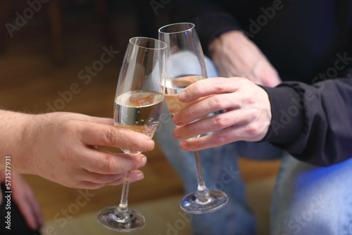 two people clinking glasses with champagne
