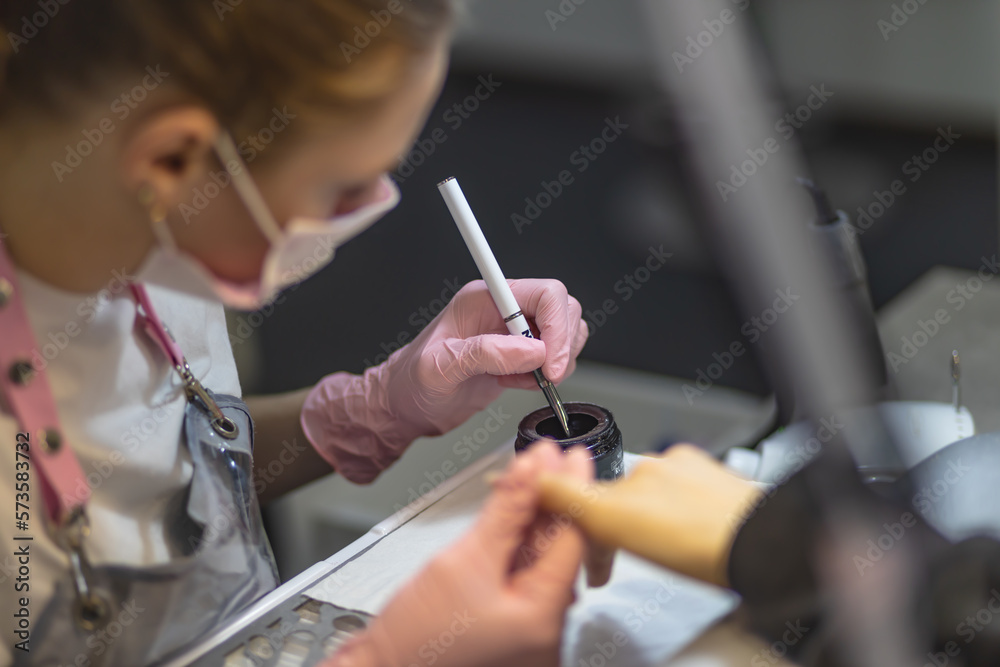 The manicurist cleans and removes the cuticle from the nail plate. Manicure process. Cut manicure technique. Special equipment for trimmed manicure. The manicurist cleans and removes the cuticle from the nail plate. Manicure process. Cut manicure technique. Special equipment for trimmed manicure.