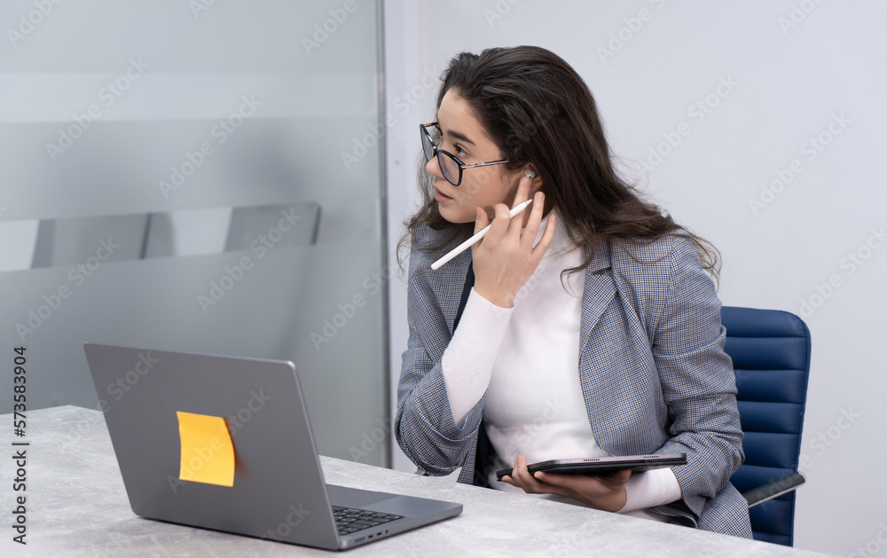 Business woman adjusting the sound on her headphones