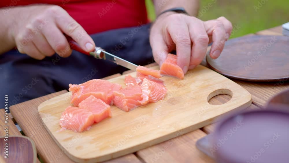 Travel kitchen. Slicing fish on a wooden board. Cooking red fish. Camera zoom Travel kitchen. Slicing fish on a wooden board. Cooking red fish. Camera zoom