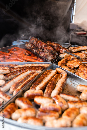 Tasty hot grilled sausages, chicken wings and barbecue in street market ready to eat