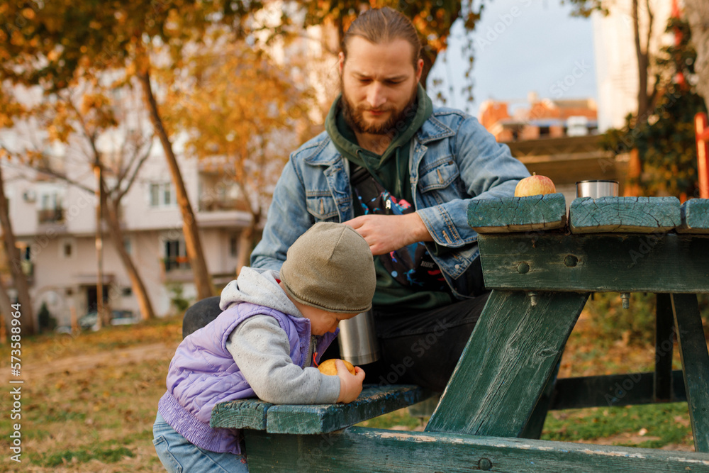 Dad and child have a picnic in the city park. Dad and child have a picnic in the city park.