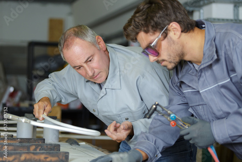 man overseeing trainee working with blowtorch