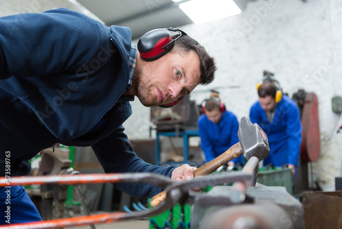 Φωτογραφία master works with a hammer in the workshop