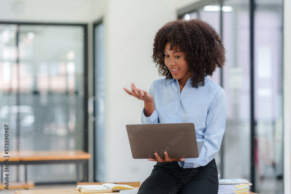 Business woman having video call with customer on laptop in office. Business woman having video call with customer on laptop in office.