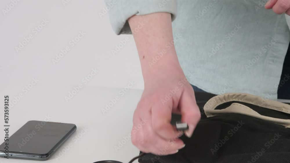 Woman hand connects her phone to USB charging port in black bag, 4k Woman hand connects her phone to USB charging port in black bag, 4k